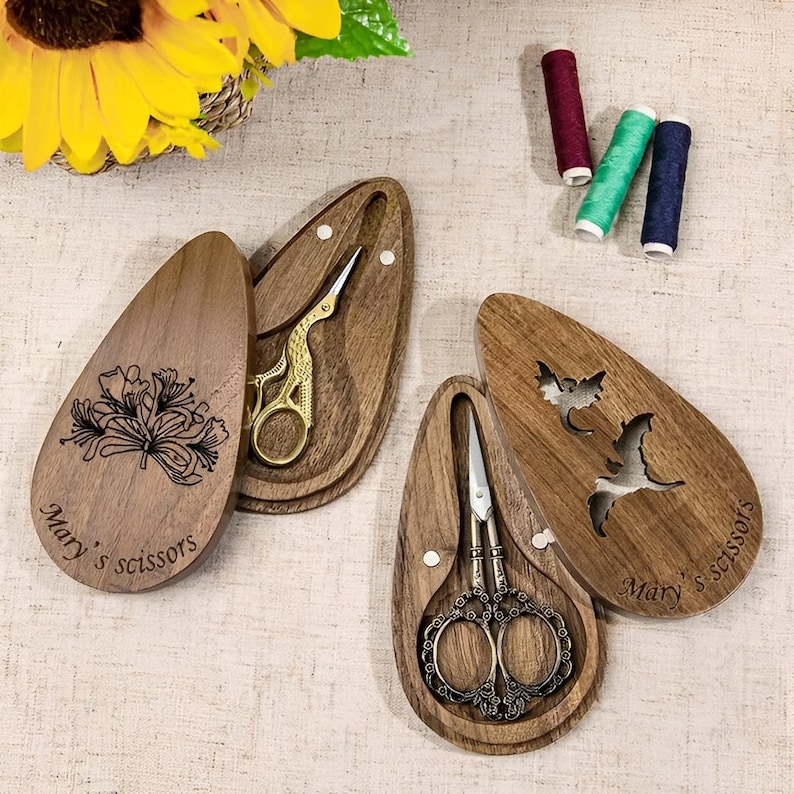 A pair of vintage-style scissors with stork-shaped handles. The scissors come with a wooden box that has a magnetic closure and a custom name or message engraved on it. It is a unique gift for seamstresses.