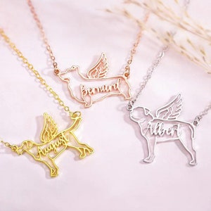 Puede incluir: Tres collares de oro, plata y oro rosa con siluetas de perros. Cada perro tiene alas y un nombre inscrito en la silueta. Los nombres son "August", "Bernard" y "Albert".