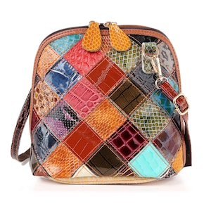 May include: A colorful, patchwork leather crossbody bag. The bag features a variety of textures and colors, including red, blue, orange, and brown. It has a top zipper closure, a brown strap, and gold-tone hardware.