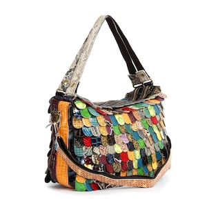 May include: A colorful shoulder bag with a unique design. The bag features a patchwork of various materials and colors, including green, blue, yellow, and red. The strap has a snakeskin pattern, and the bag has a brown trim.
