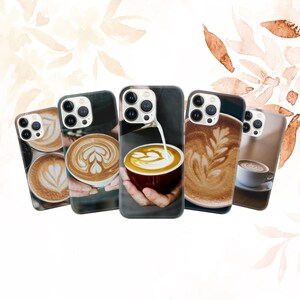 May include: Five different iPhone cases with latte art designs. The cases are all black and feature different latte art designs, including a heart, a flower, and a swirl.