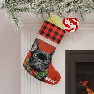 May include: A red and black plaid Christmas stocking with a white cuff. The stocking features a painting of a black French bulldog wearing a green and red scarf. The stocking is personalized with the name "Billy".