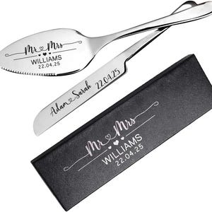 May include: A silver-toned cake server and knife set with engraved text reading Mr & Mrs WILLIAMS 22.04.25 and Adam & Sarah 22.04.25, accompanied by a black rectangular gift box featuring the same Mr & Mrs WILLIAMS 22.04.25 inscription in white.