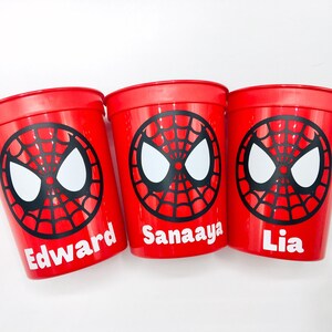 Puede incluir: Tres vasos de pl&aacute;stico rojos con un dise&ntilde;o de Spiderman y los nombres "Edward", "Sanaaya" y "Lia" impresos en ellos.
