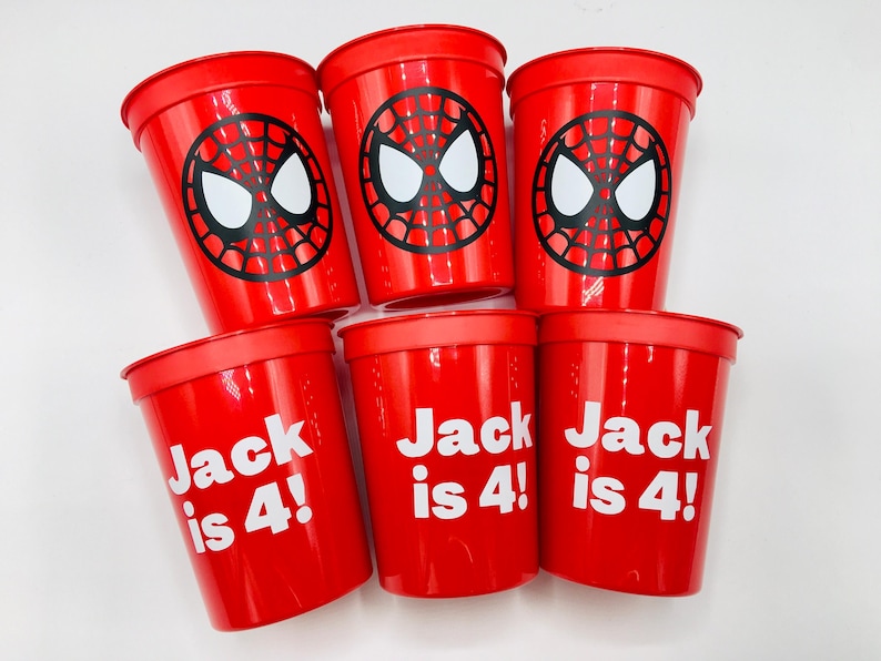 Puede incluir: Seis vasos de pl&aacute;stico rojos con un dise&ntilde;o de Spider-Man. Tres vasos tienen el texto "Jack is 4!" impreso en blanco.