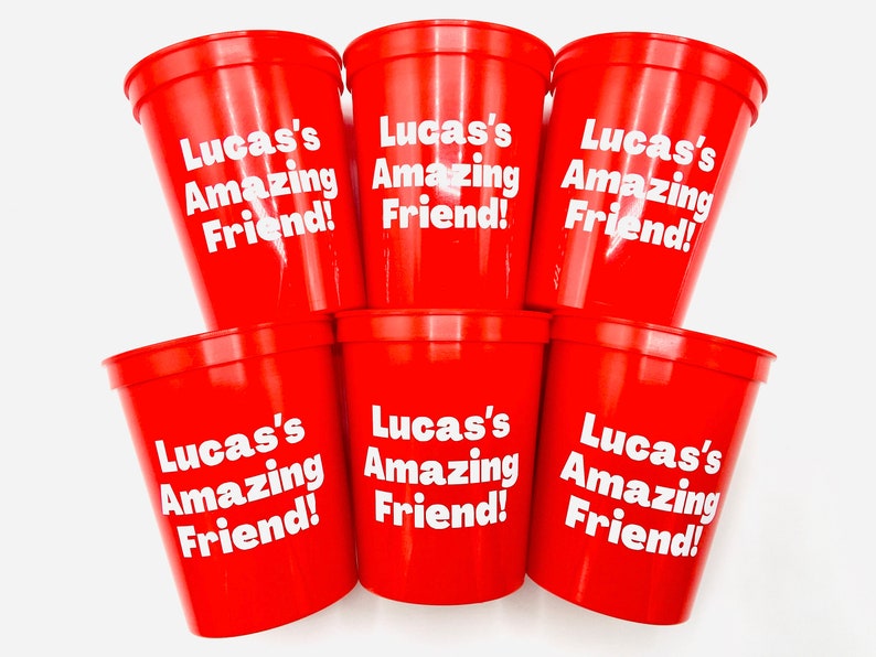 Puede incluir: Seis vasos de pl&aacute;stico rojos con texto blanco que dice "Lucas's Amazing Friend!"