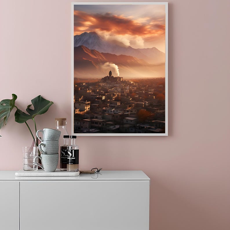 May include: A framed photograph of a city nestled in a valley with mountains in the background. The sky is a vibrant orange and pink with clouds. The city is lit by the setting sun.