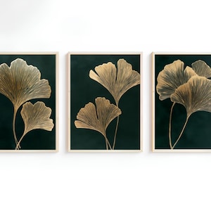 Könnte beinhalten: Drei gerahmte Drucke mit dunkelgrünem Hintergrund und goldenen Ginkgoblatt-Illustrationen.