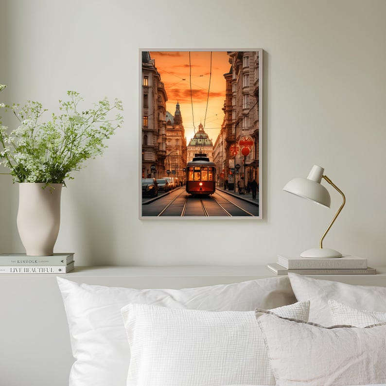 May include: A vintage red streetcar travels down a city street lined with buildings. The sun is setting, casting a warm orange glow over the scene.
