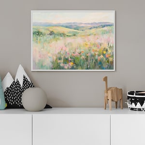 K&ouml;nnte beinhalten: Ein gerahmtes Gem&auml;lde, das ein Feld mit Wildblumen in einer Landschaft zeigt. Das Gem&auml;lde ist in einem wei&szlig;en Rahmen und zeigt eine Vielzahl von Farben, darunter Pink, Gelb und Gr&uuml;n.