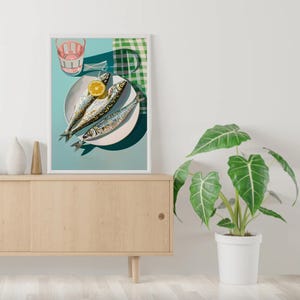 May include: A still life photograph of three whole fish on a white plate with a lemon wedge. The plate is on a blue background with a green and white checkered cloth in the background. A glass of pink liquid is in the upper left corner of the image.