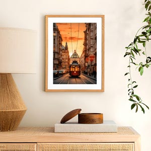 May include: A vintage red streetcar travels down a city street at sunset. The streetcar is illuminated by the warm glow of the setting sun. The buildings on either side of the street are tall and narrow, with ornate details. The sky is a vibrant orange and pink.