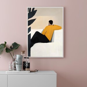 Pode incluir: Uma ilustra&ccedil;&atilde;o emoldurada de uma pessoa sentada em um sof&aacute; branco, olhando para fora de uma janela. A pessoa est&aacute; vestindo um su&eacute;ter amarelo e cal&ccedil;as pretas. Uma planta preta e branca &eacute; vis&iacute;vel no fundo.