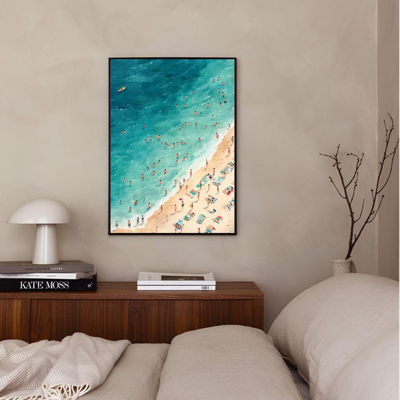 May include: A framed watercolor painting of a beach scene with turquoise water and a sandy shore.  People are swimming and sunbathing on the beach.