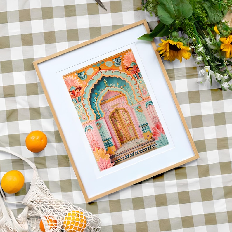 May include: A framed print of a colorful illustration of a pink building with a teal and gold door. The building has intricate details and is decorated with flowers.