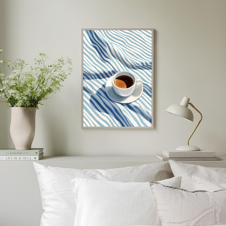 May include: A white coffee cup with brown coffee inside, sitting on a white saucer on a blue and white striped fabric.