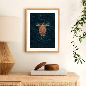 May include: A framed print of a sea turtle with a brown shell and flippers, swimming on a dark blue background.
