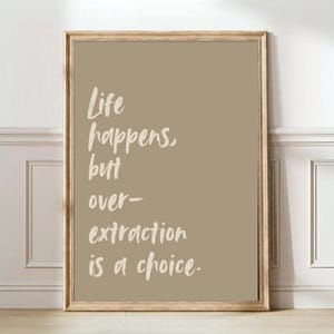 May include: A framed print with a beige background and white text that reads "Life happens, but over-extraction is a choice."