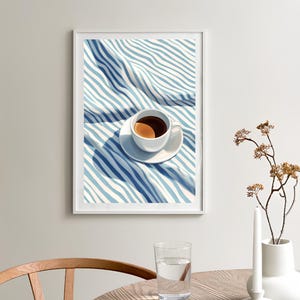 May include: A white coffee cup with a brown coffee inside, sitting on a white saucer on a blue and white striped fabric.