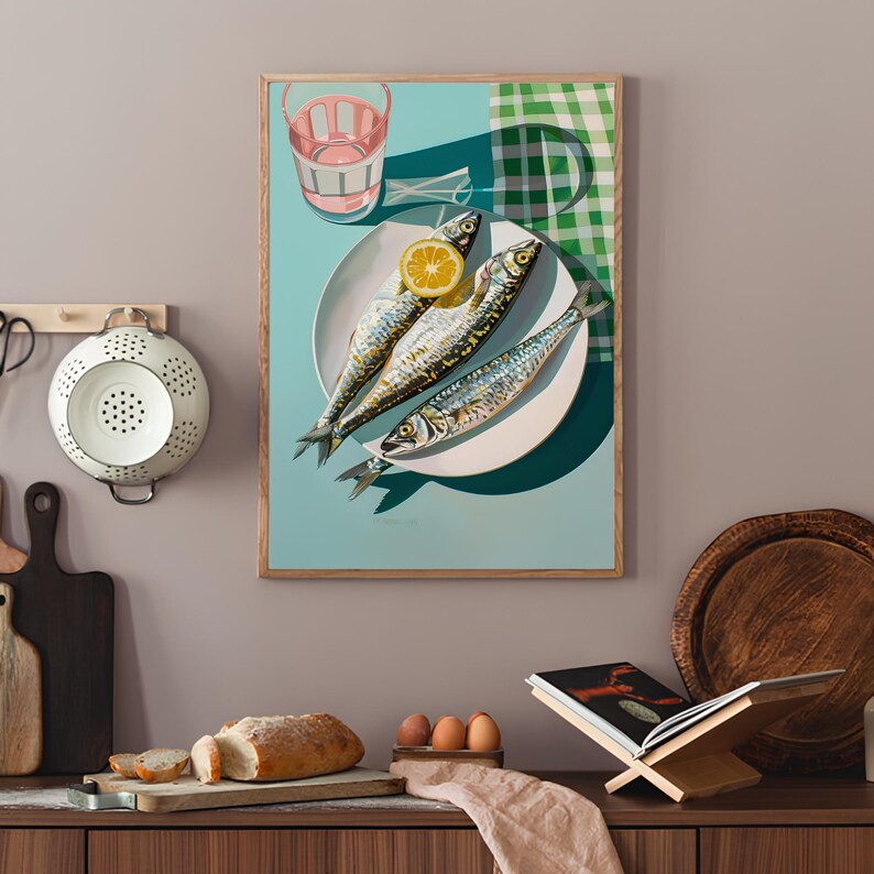 May include: A framed print of a still life featuring three whole fish on a white plate with a lemon wedge. The plate is on a blue background with a green and white checkered cloth in the background.