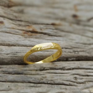 Pode incluir: Um anel de banda de ouro simples com uma superfície texturizada.