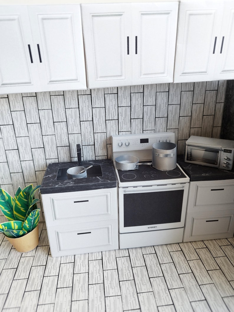 A digital printable template for a 1:12 scale dollhouse mini kitchen sink, designed for BMM system dollhouse setups. The template features a detailed, modern kitchen sink with a sleek faucet, ready to be printed on regular paper, cut, and assembled for a miniature kitchen scene.