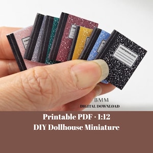 Pode incluir: Uma coleção de cadernos de composição em miniatura em várias cores, incluindo rosa, cinza, verde-azulado, bordô, amarelo, azul e preto. Cada caderno tem uma lombada preta e uma etiqueta branca. A imagem inclui o texto "BMM DIGITAL DOWNLOAD" e "Printable PDF 1:12 DIY Dollhouse Miniature."