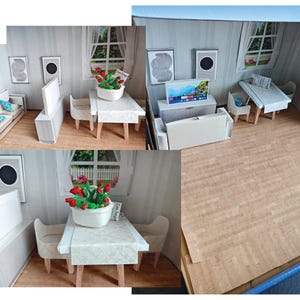 May include: A miniature dollhouse living room with a white couch, a TV stand with a flat screen TV, and a dining table with four chairs. The dining table has a white tablecloth and a small potted plant with red flowers. The floor is a light brown wood laminate.
