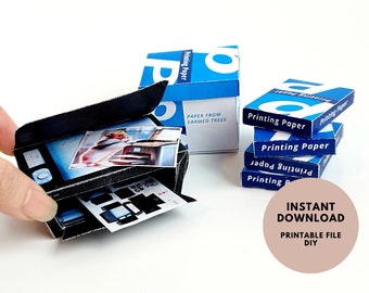 May include: Printable papercraft model of a printer with an open paper tray and a photo of a hamster printing. The printer is next to a stack of blue and white boxes of paper that say "Printing Paper" and "Paper from Farmed Trees".