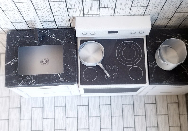 A digital printable template for a 1:12 scale dollhouse mini kitchen sink, designed for BMM system dollhouse setups. The template features a detailed, modern kitchen sink with a sleek faucet, ready to be printed on regular paper, cut, and assembled for a miniature kitchen scene.