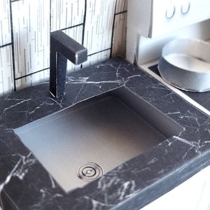 A digital printable template for a 1:12 scale dollhouse mini kitchen sink, designed for BMM system dollhouse setups. The template features a detailed, modern kitchen sink with a sleek faucet, ready to be printed on regular paper, cut, and assembled for a miniature kitchen scene.