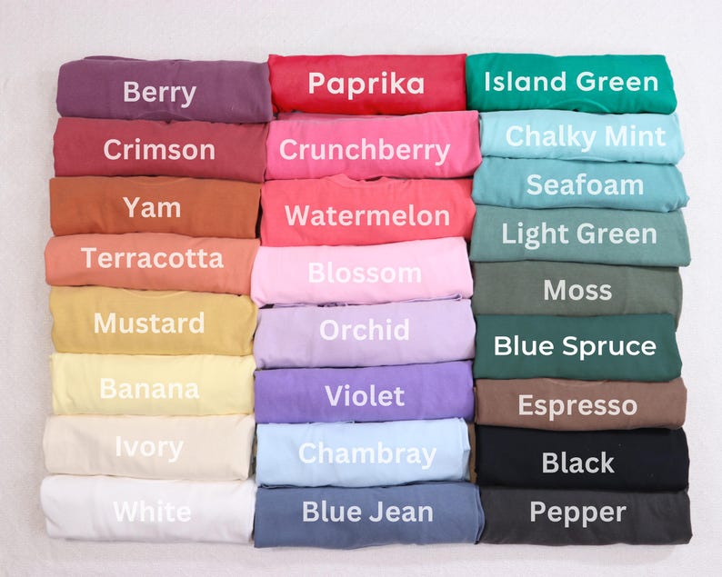 A collection of colorful t-shirts with various colors and patterns, including berry, paprika, island green, crunchberry, watermelon, light green, terracotta, pink, white, blue jean, black, and black pepper.