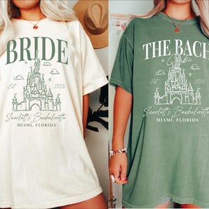 two women wearing t-shirts with the same design, which appears to be a graphic or illustration of a castle or palace. The text on the t-shirts reads "Bridal" and "The Bachelorette" along with the location "Miam, Florida".