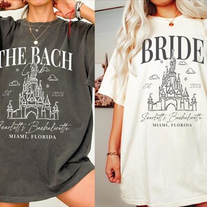 two t-shirts with the same design, one gray and one white, both with the text "THE BACH" and "Scottie's Bachelorette" printed on them.