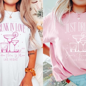 May include: Two white t-shirts with pink text and graphics. The first shirt says "Drunk in Love" with a margarita glass graphic and the text "Future Mrs. Williams Las Vegas". The second shirt says "Just Drunk" with a margarita glass graphic and the text "Jenna's Bachelorette Las Vegas".