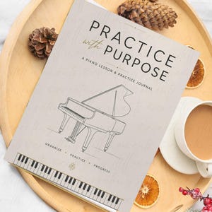 Könnte beinhalten: Ein beigefarbenes Klavierübungsheft mit dem Titel Practice with Purpose, das eine schwarze Strichzeichnung eines Flügels, eine Klaviatur-Bordüre sowie die Wörter Organize, Practice, Progress auf dem Einband zeigt.