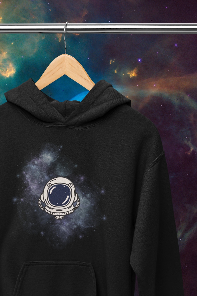 May include: Black hoodie with a white astronaut helmet graphic against a blue and purple galaxy background.