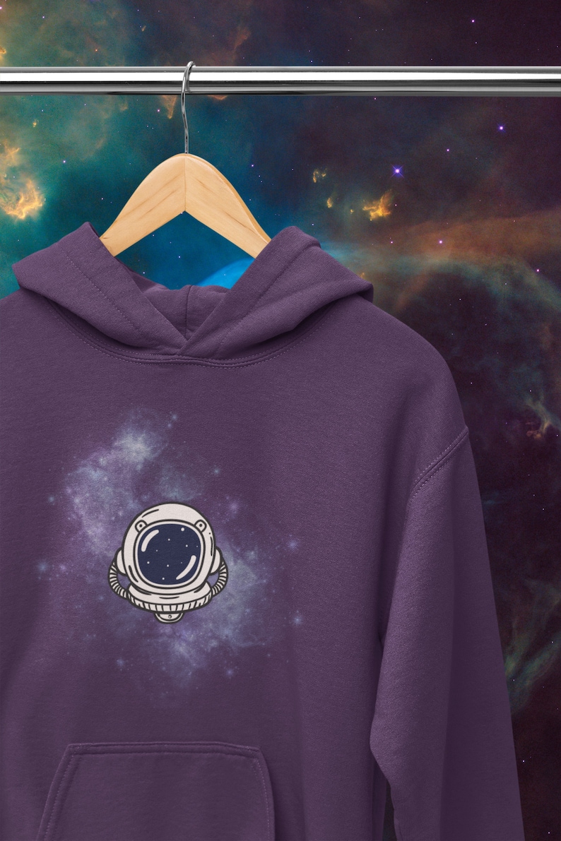 May include: Purple hoodie with a white astronaut graphic on a galaxy background.