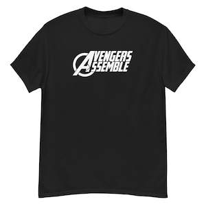 Könnte beinhalten: Schwarzes T-Shirt mit einem weißen Aufdruck des Avengers-Logos und dem Text "Avengers Assemble".