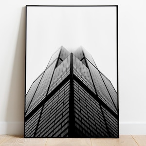 May include: Black and white photograph of a tall skyscraper with a geometric design. The building is framed against a white background.
