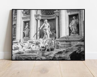 May include: A black and white photograph of the Trevi Fountain in Rome, Italy. The fountain is adorned with statues of mythological figures, including a central figure of Oceanus, the god of the sea, riding a chariot drawn by seahorses.
