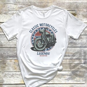 Op de afbeelding: Wit T-shirt met een vintage-stijl grafische afbeelding van een motorfiets in een cirkel met de tekst "Classic Motorcycles" en "Legends Never Die".