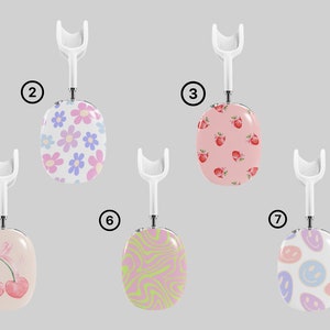 Puede incluir: Siete fundas de tel&eacute;fono con diferentes patrones, cada una con un gancho blanco. Las fundas presentan varios dise&ntilde;os, incluyendo espirales, flores, cerezas y caras sonrientes. Las fundas son todas de colores pastel.
