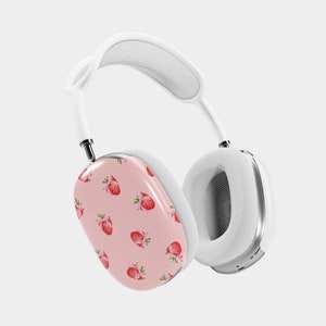 Puede incluir: Auriculares inal&aacute;mbricos blancos con una almohadilla rosa con un patr&oacute;n de fresas. Los auriculares tienen una diadema y almohadillas blancas.