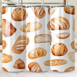 May include: Three white stainless steel tumblers featuring a pattern of different breads and rolls. The tumblers are all the same size and shape, with a white background and a brown pattern.