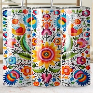 May include: Three stainless steel tumblers with a colorful floral design. The design features a variety of flowers in shades of red, orange, yellow, blue, and green. The flowers are arranged in a symmetrical pattern on a white background.