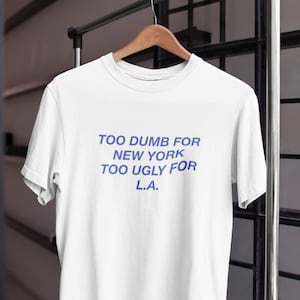 Demasiado tonto para Nueva York Demasiado feo para la camiseta de Los Ángeles - Camiseta divertida - Meme Y2K Gen Z - Texto blanco - Camiseta gráfica estética de moda - Cita extraña y extraña