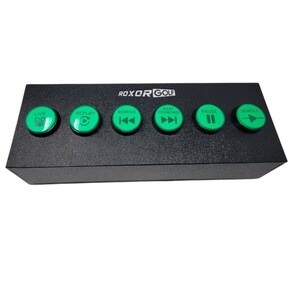 May include: A black control panel with six green buttons labelled "Live", "Replay", "Rewind", "Fast Forward", "Pause", and "Scroll". The panel has the text "ROXOR GOLF" printed on the front.