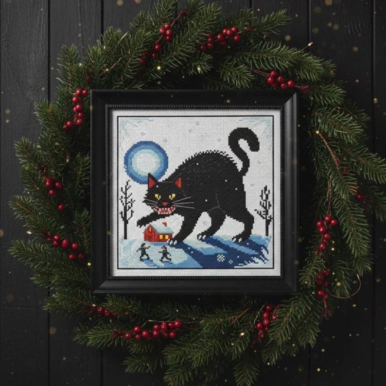 Finished Jólakötturinn cross stitch framed and displayed within a dark, Pagan-themed Christmas wreath.