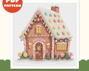 Op de afbeelding: Een kruissteekpatroon van een peperkoekhuisje met een wit glazuurdak versierd met kleurrijke snoepjes, een bruine bakstenen gevel, een centrale deur, gele ramen en een schoorsteen, alles op een witte achtergrond met raster.